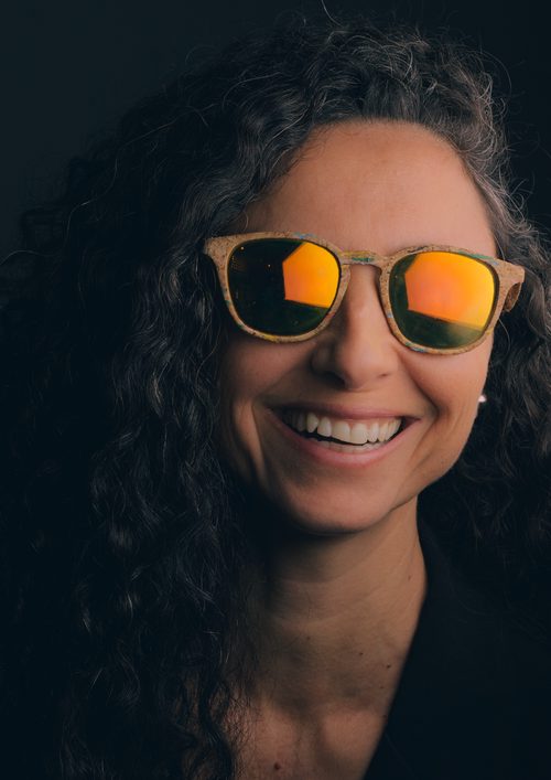 Fashion portrait of a smiling woman wearing reflective sunglasses
