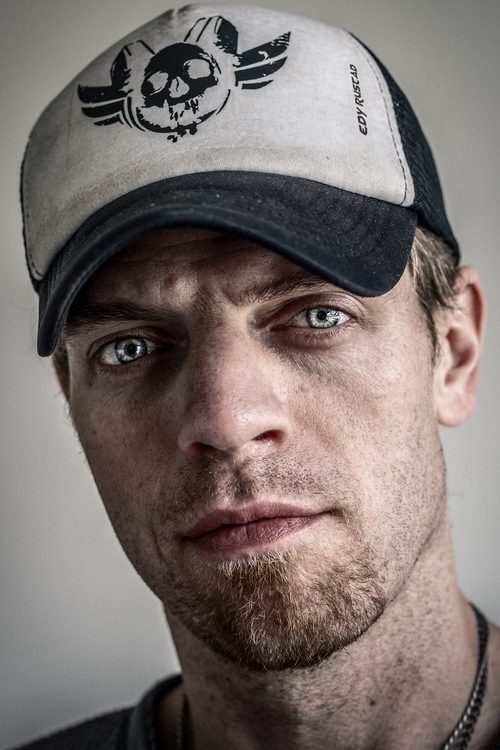Close-up black and white portrait of a man wearing a worn baseball cap